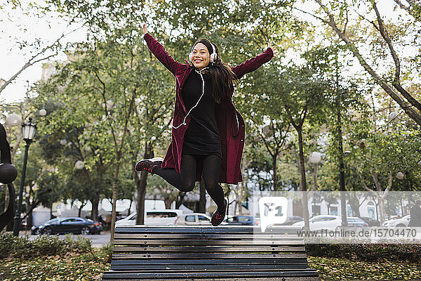 Porträt spielerische überschwängliche Frau springt von städtischen Stadt Bank