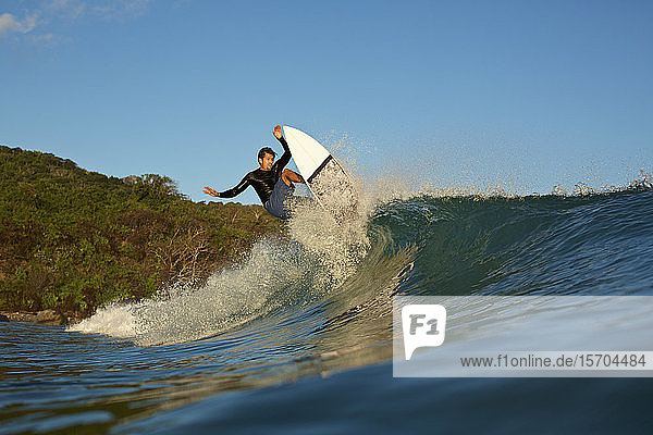 Männlicher Surfer reitet auf einer Meereswelle
