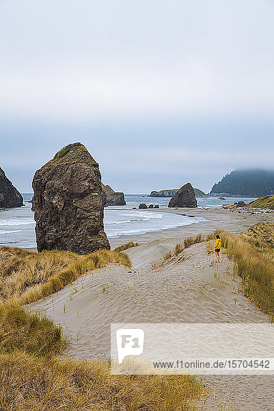 Einsame Wanderin am zerklüfteten Küstenstrand am launischen Nachmittag  Oregon  USA