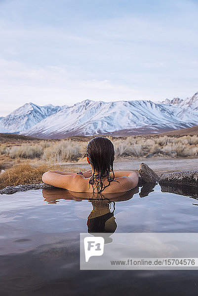 Woman enjoying hot spring in cold winter  Mammoth Lakes Hot Spring  California  USA