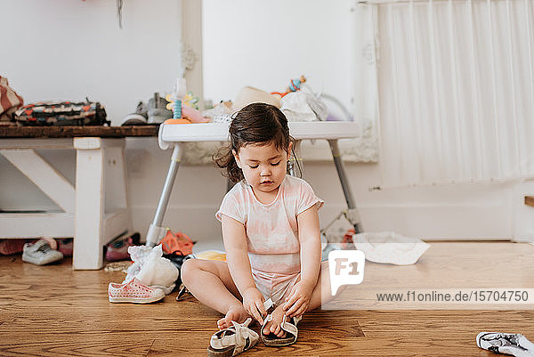 Toddler putting on shoes in living room