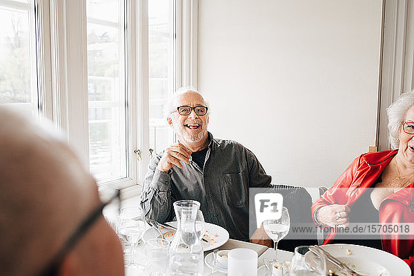 Glückliche Seniorenfreunde genießen es  im Restaurant zu sitzen