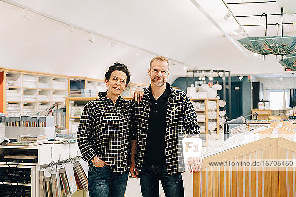 Portrait of smiling male and female employees standing in store