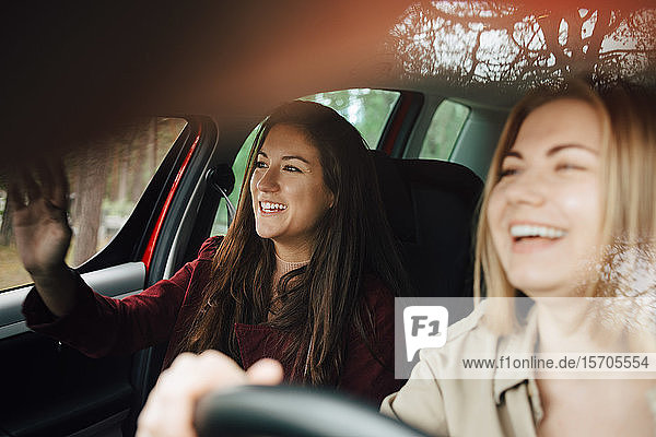 Happy female friends traveling together in car