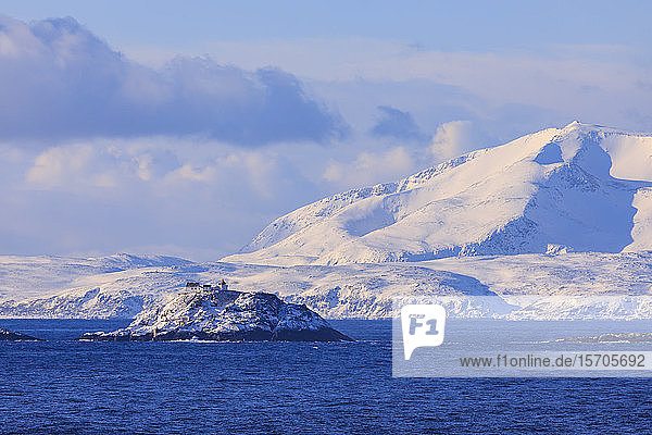 Leuchtturm  Norwegische See  spektakuläre schneebedeckte Berge im Winter  Troms-Inseln  Polarkreis  Nordnorwegen  Europa