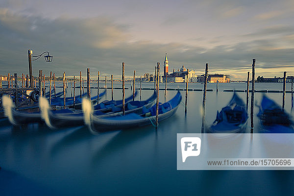 Gondeln an ihren Liegeplätzen  während das letzte Licht des Tages San Giorgio Maggiore und den Campanile beleuchtet  Venedig  UNESCO-Weltkulturerbe  Venetien  Italien  Europa