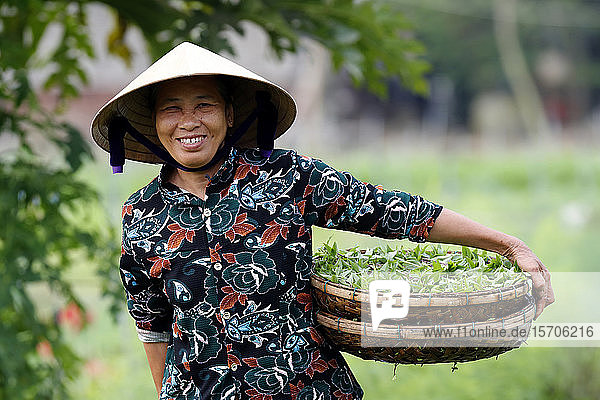 Lächelnde Vietnamesin mit dem traditionellen konischen Hut aus Palmblättern  Hoi An  Vietnam  Indochina  Südostasien  Asien