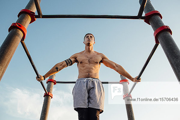 Young man practicing calisthenics at an outdoor gym
