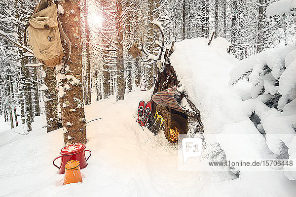 Wooden shelter in a winter forest with tea pots and snowshoes  salzburg State  Austria