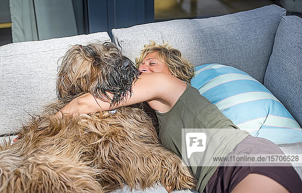 Woman cuddling with dog on terrace at home
