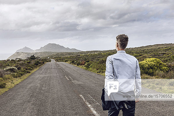 Rückansicht eines Geschäftsmannes auf einer Landstraße  Cape Point  Western Cape  Südafrika