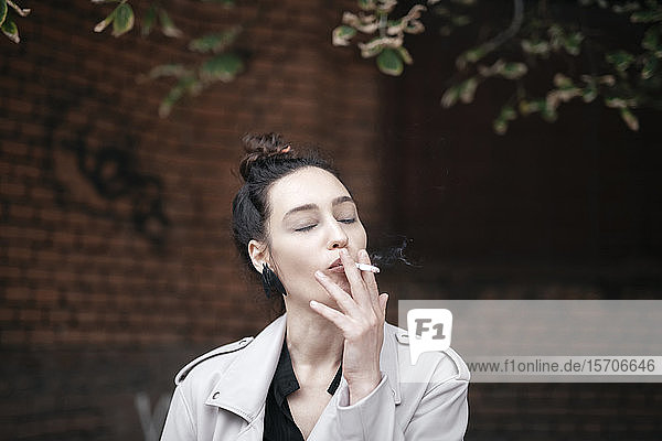 Portrait of woman smoking with eyes closed