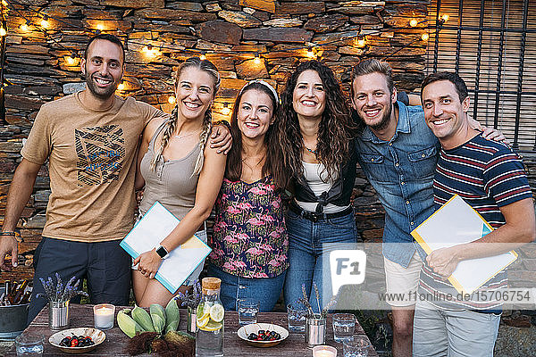 Gruppenporträt von glücklichen Freunden im Freien an einem Steinhaus