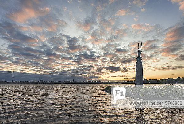 Germany Hamburg Outer Alster Lake with sculpture Three Men in the Boat by Edwin Paul Scharff at sunset