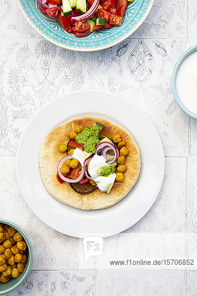 Israelischer Sabich mit Fladenbrot Auberginen Kichererbsen Zwiebeln Tomaten Gurken Joghurt und Zhug-Sauce