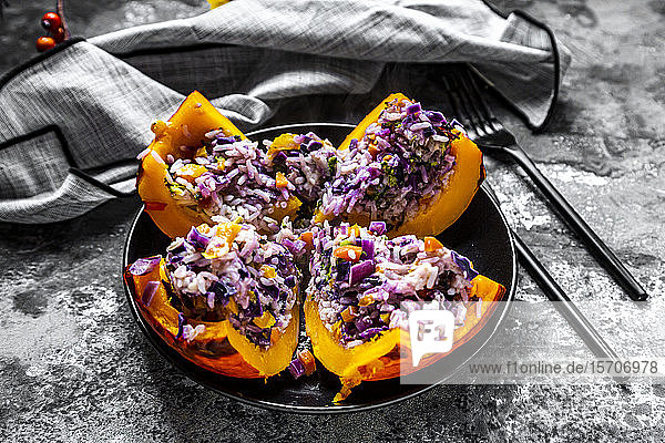 Ein geviertelter Hokkaido-Kürbis gefüllt mit Reis  Rotkohl  Paprika  Brokkoli  Zwiebeln und Karotten