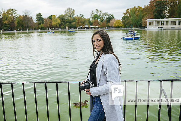 Frau mit Kamera an einem See im Park El Retiro  Madrid  Spanien