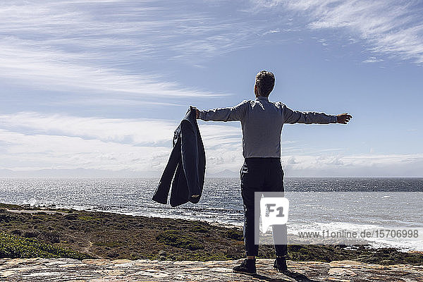 Back view of businessman standing in front of the sea  Cape Point  Western Cape  South Africa
