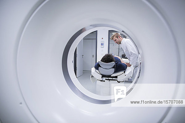 Patient im Krankenhaus während CT-Untersuchung und Radiologe