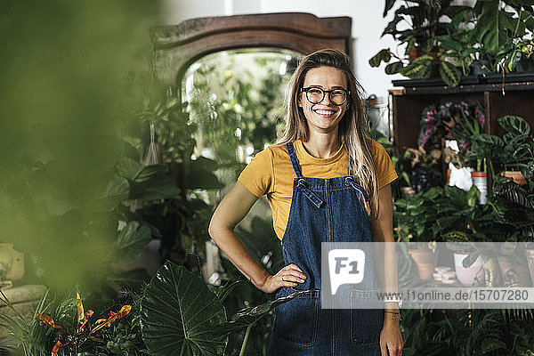 Porträt einer glücklichen jungen Frau in einem kleinen Gartenbaubetrieb
