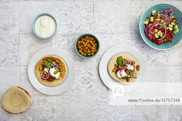 Israelischer Sabich mit Fladenbrot Auberginen Kichererbsen Zwiebeln Tomaten Gurken Joghurt und Zhug-Sauce