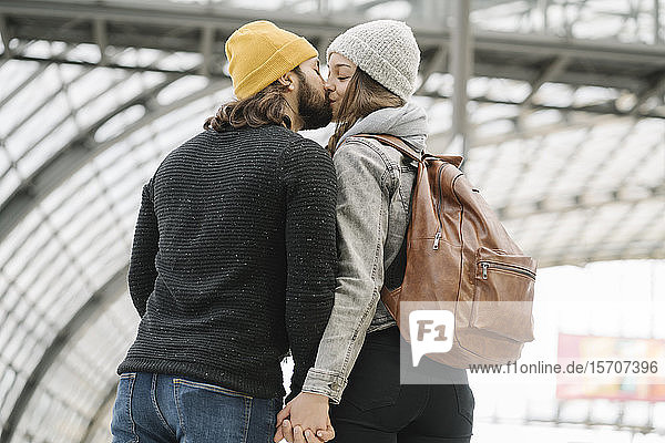 Junges Paar küsst sich auf dem Bahnsteig  Berlin  Deutschland