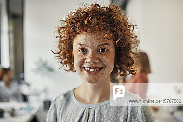 Portrait of a smiling redheaded businesswoman in office