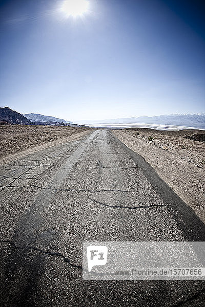 USA  Kalifornien  Sonne scheint über rissiger Straße im Death Valley