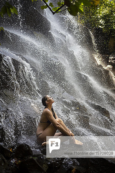 Junge Frau in der Nähe des Kanto-Lampo-Wasserfalls  Bali  Indonesien