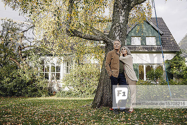 Älteres Ehepaar im Herbst im Garten ihres Hauses