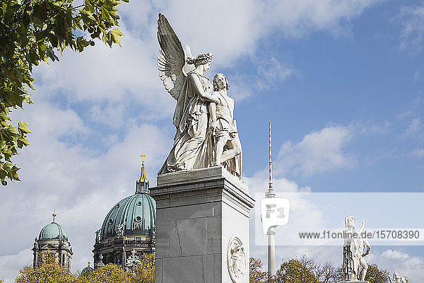 Germany Berlin Nike Assists Wounded Warrior statue with Berlin Cathedral and Berlin TV Tower in background