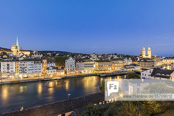 Switzerland  Canton of Zurich  Zurich  River Limmat and old town buildings along illuminated Limmatquai street at dusk