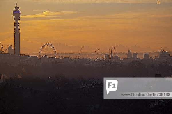 UK  England  London  Silhouettes of BT Tower  London Eye and surrounding buildings at orange sunrise
