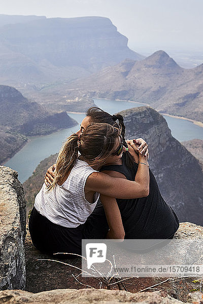 Zwei Frauen umarmen sich auf einem Felsen mit schöner Landschaft als Hintergrund  Blyde River Canyon  Südafrika