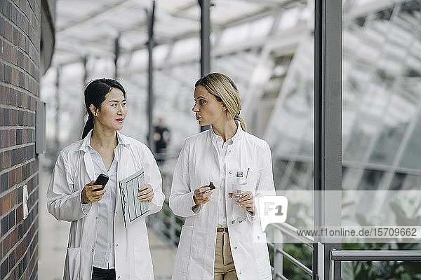 Two female doctors talking in a modern building