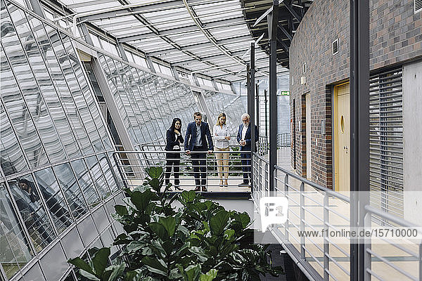 Geschäftsleute stehen auf dem Skywalk in einem modernen Bürogebäude