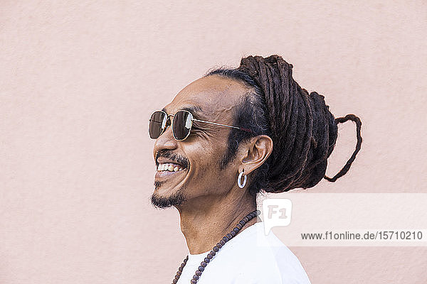 Portrait of smiling mature man with dreadlocks and sunglasses