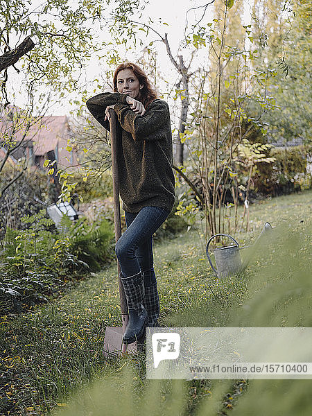 Woman working in her garden,  holding shovel