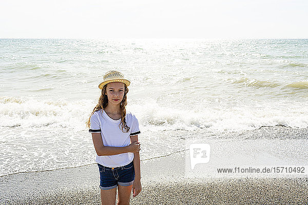 Girl with straw hat standing on the beach  Tuscany  Italy