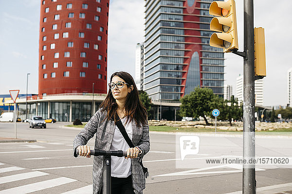 Young businesswoman with e-scooter in the city