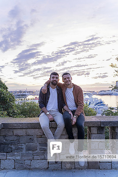 Portrait of gay couple on lookout above the city with view to the port  Barcelona  Spain