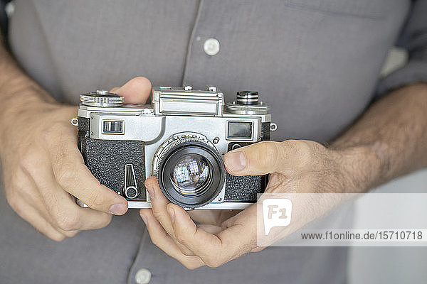 Close-up of man holding old-fashioned camera