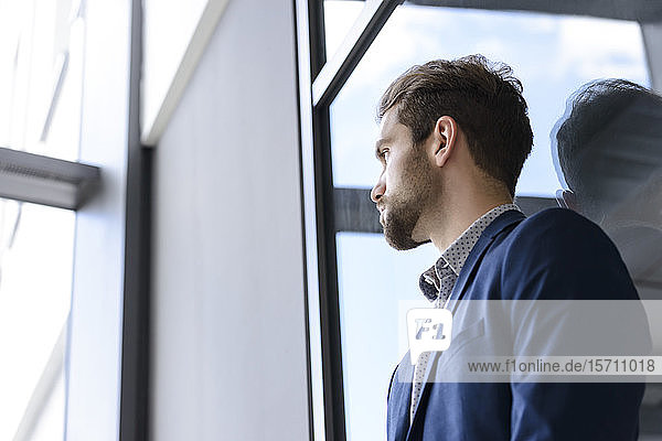 Young businessman leaning against the window
