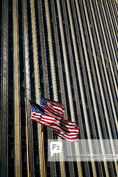 USA  New York  New York City  Three American flags against skyscraper