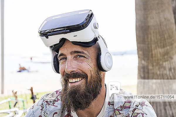 Lächelnder reifer Mann mit Virtual-Reality-Brille