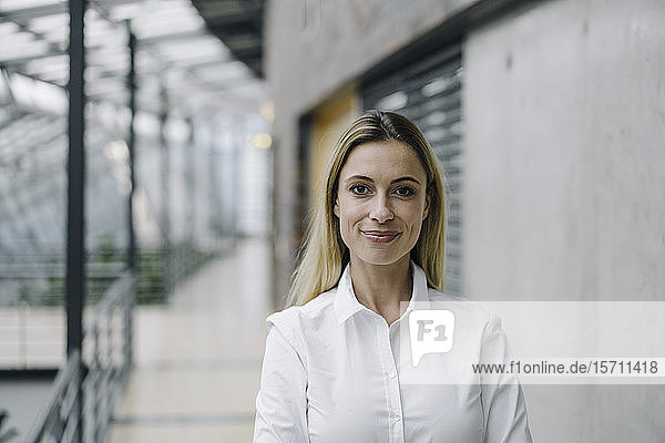 Porträt einer selbstbewussten jungen Geschäftsfrau in einem modernen Bürogebäude