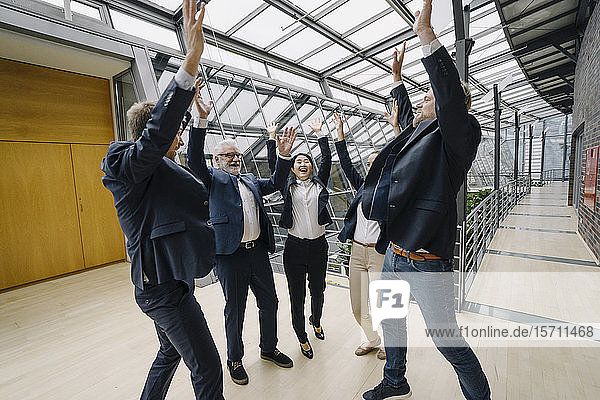 Happy business people cheering in modern office building