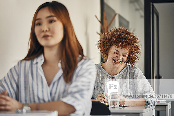 Happy businesswoman sitting at desk in a workshop
