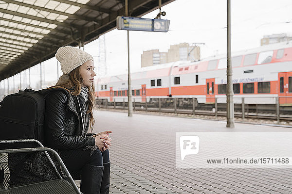 Junge Frau mit Rucksack wartet am Bahnsteig  Vilnius  Litauen