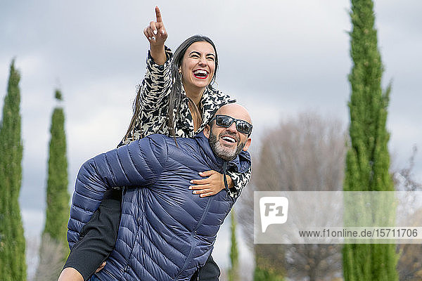 Geschäftsfrau und attraktiver Mann lächelt  Mann trägt Frau auf seinem Rücken